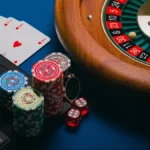 Playing cars, casino chips, roulette wheel.