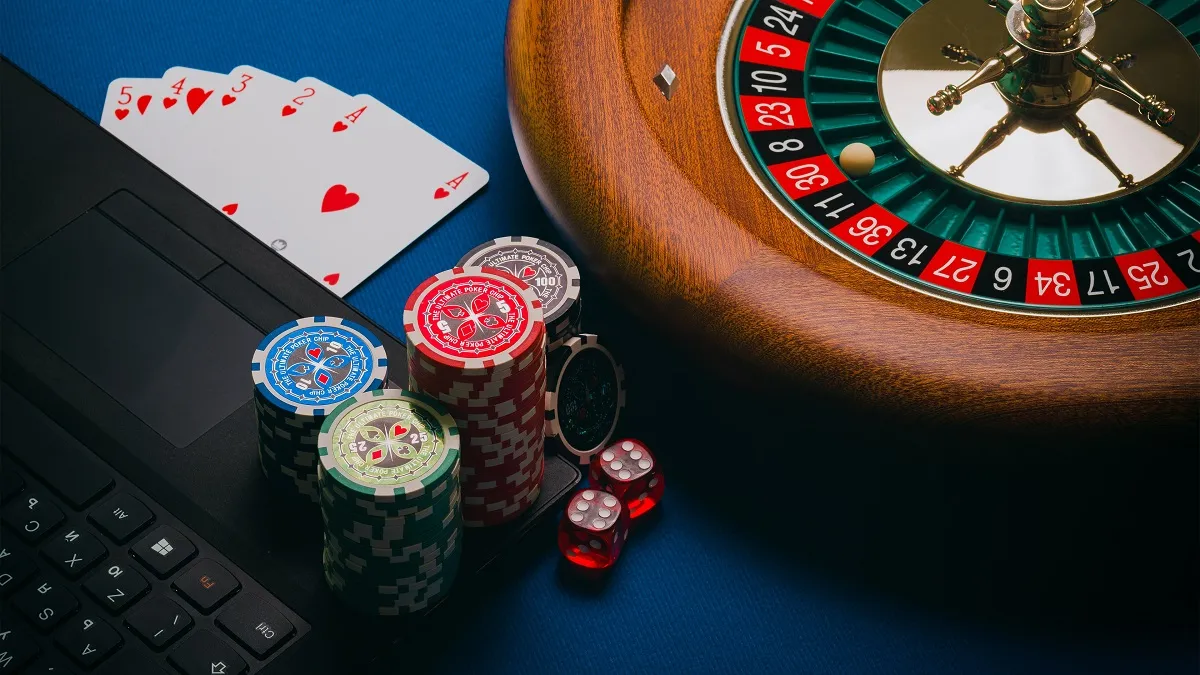 Playing cars, casino chips, roulette wheel.